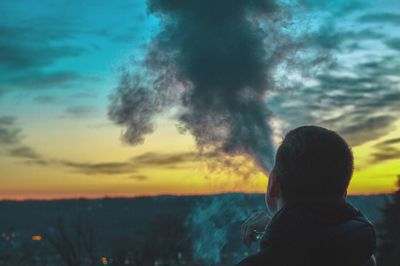 Rear view of silhouette woman looking at sunset