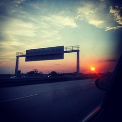 Cars on road at sunset