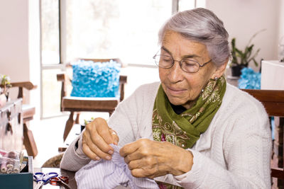 Senior woman sewing mask at home