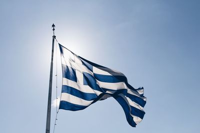 Low angle view of greek flag against clear blue sky during sunny day
