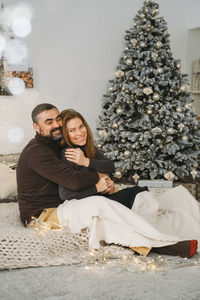 Happy couple celebrating romantic christmas eve at home. christmas interior decoration for family