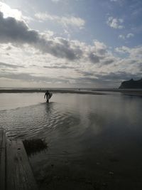 Silhouette person standing on beach against sky