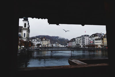 River amidst buildings in town against sky