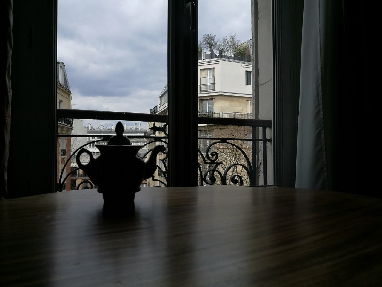 window, indoors, transparent, one person, glass - material, sitting, sky, silhouette, seat, rear view, lifestyles, day, home interior, architecture, men, real people, cloud - sky, flooring, chair, waiting, contemplation