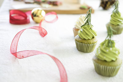 Close-up of cupcakes and ribbon on table