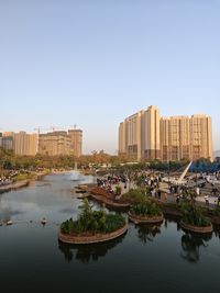 Buildings by river against clear sky