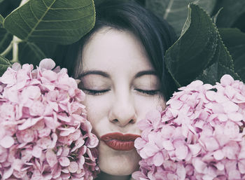 Close-up portrait of woman with pink flower