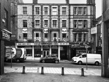 Vehicles on road against building