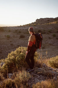 Full length of man standing on rock against sky