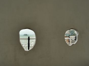 Street light by sea seen through window