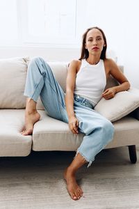 Young woman sitting on sofa at home