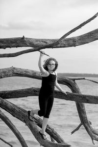 Girl climbing on branches at the beach