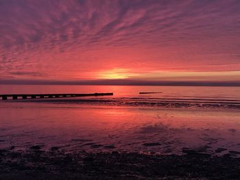 Scenic view of sea against romantic sky at sunset