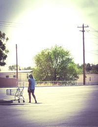 Rear view of woman standing on road