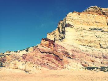 Low angle view of rock formation against clear blue sky