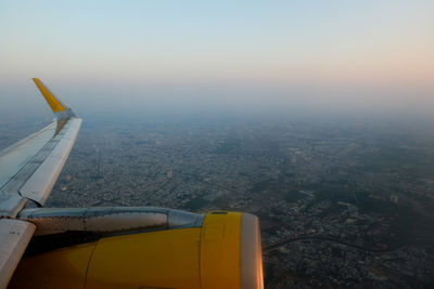 Cropped image of airplane against sky at sunset