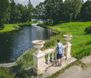 Rear view of woman standing by lake