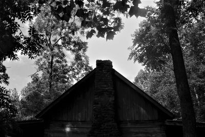 Low angle view of trees and building against sky