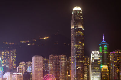 Illuminated buildings in hong kong city against sky at night