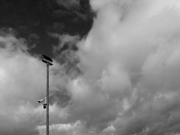 Low angle view of floodlight against cloudy sky