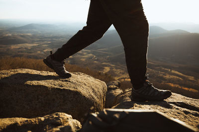 Low section of man standing on rock