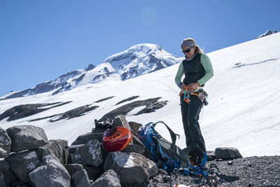 Female mountaineer secures her harness at base camp mt. baker