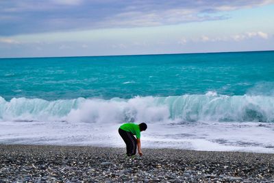 Rear view of man on beach against sky