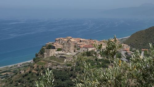 Scenic view of sea by buildings against sky