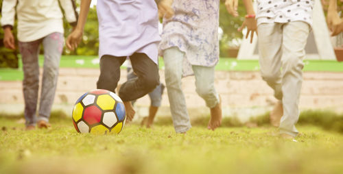 Low section of people playing soccer ball