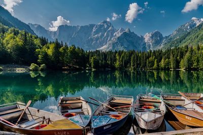 Boats moored in lake against mountains
