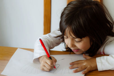 Close-up of girl holding paper at home