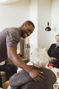 Smiling male healthcare worker talking with senior woman in retirement home