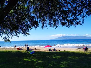 People at beach against sky