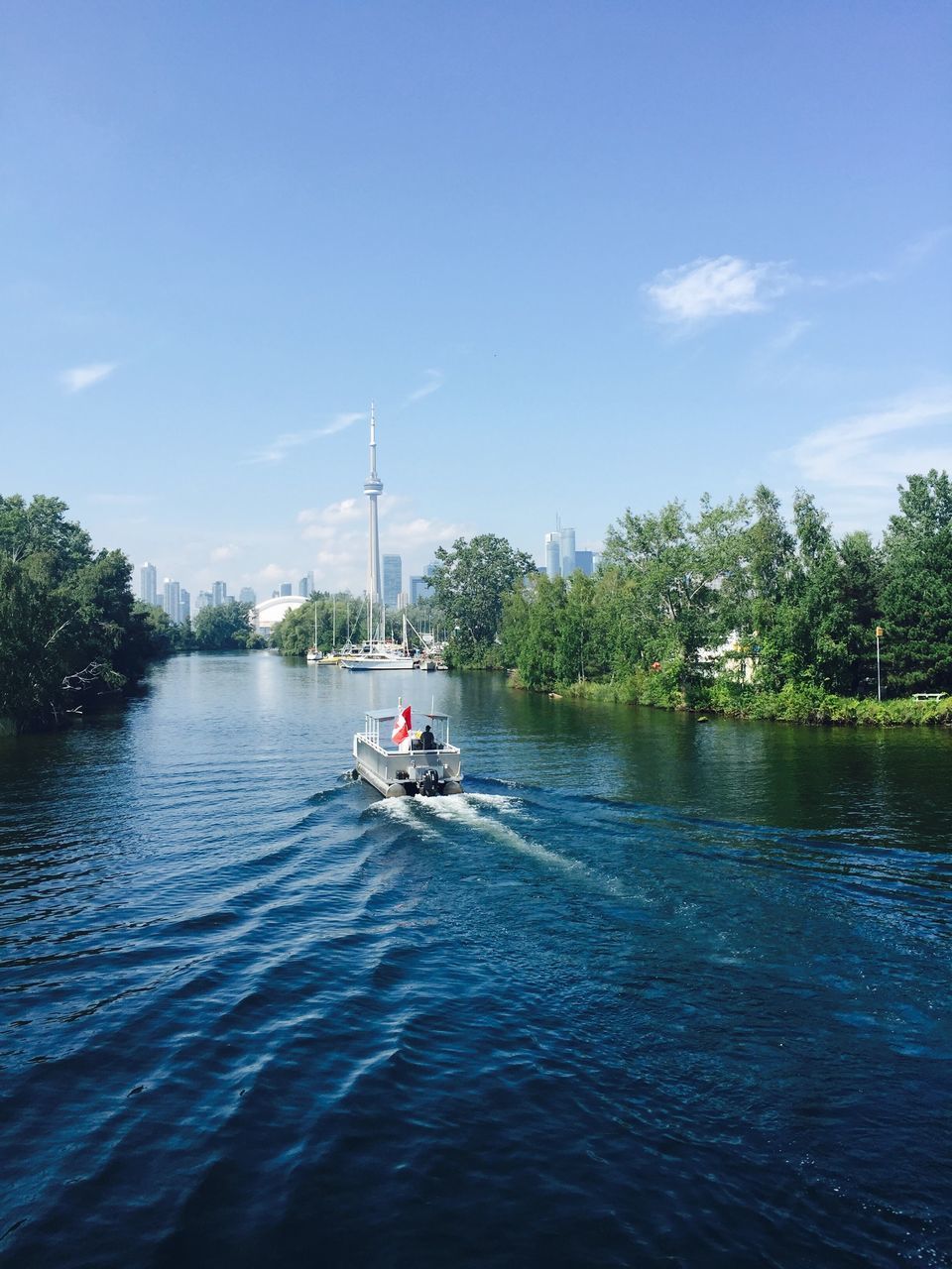 BOAT SAILING IN RIVER AGAINST SKY