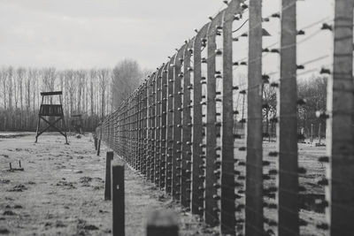 Fence on field against sky during winter