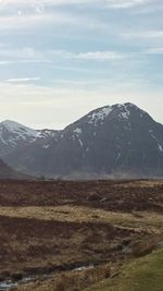 Scenic view of mountains against cloudy sky