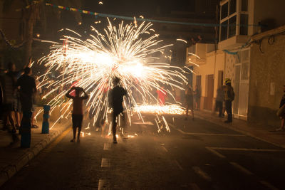 People watching firework display at night