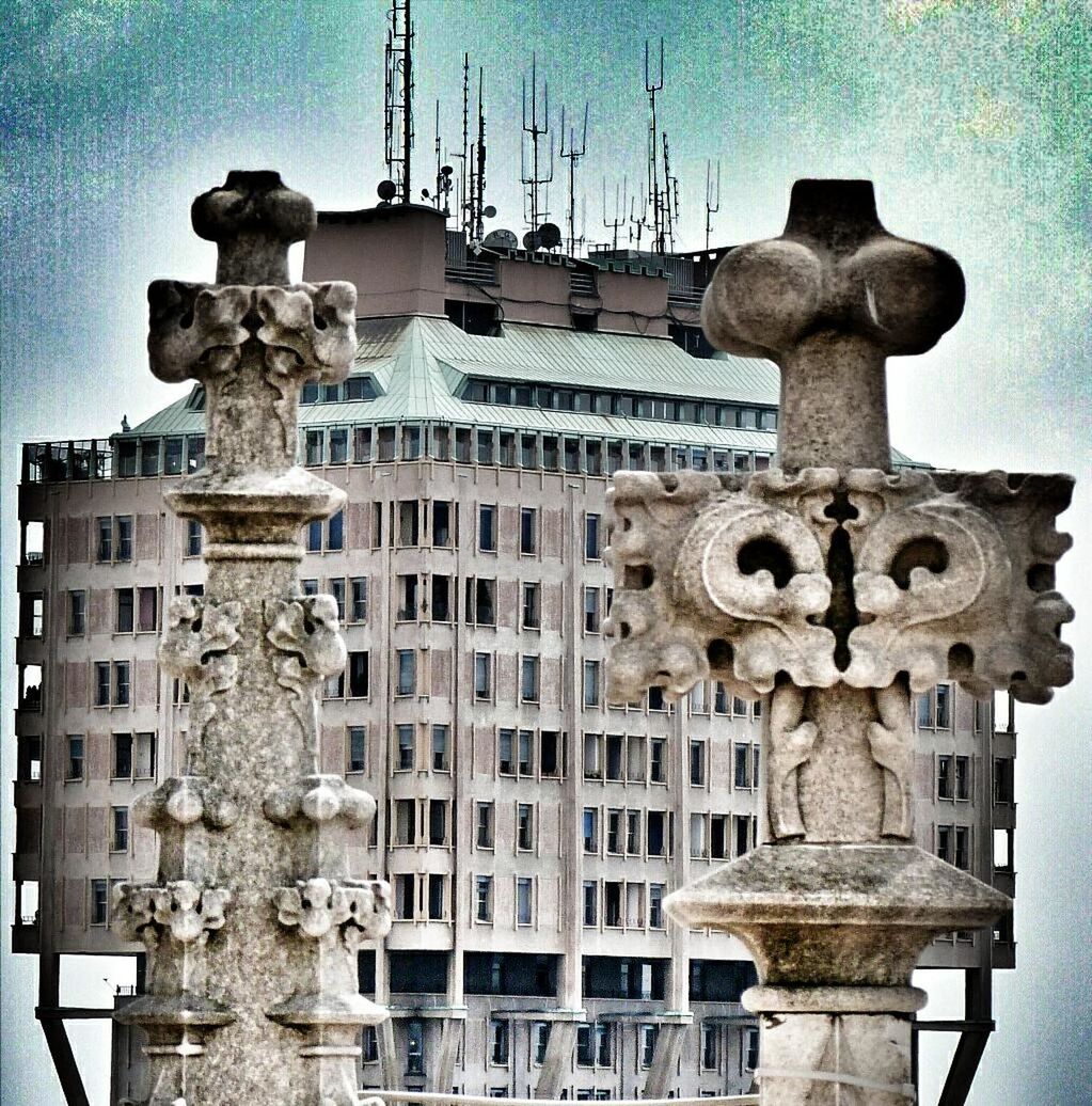 architecture, built structure, building exterior, low angle view, sky, old, human representation, sculpture, day, no people, outdoors, statue, history, connection, metal, art and craft, art, street light, power line, cable