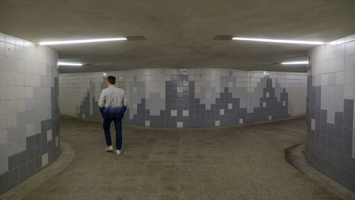 Full length rear view of man walking in subway