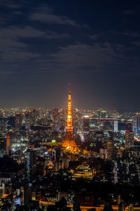 Illuminated cityscape against sky at night