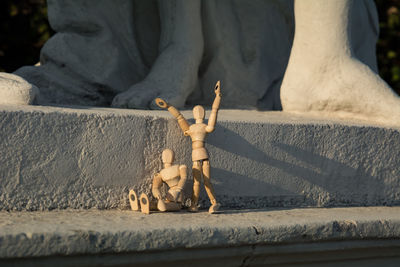 Wooden dolls against statue