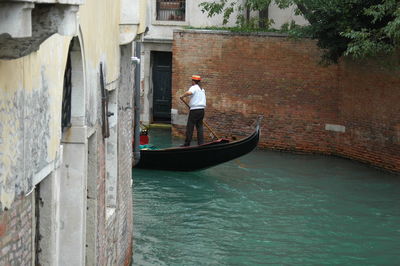 Man standing on boat in canal