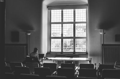 Rear view of woman using laptop on table