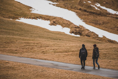 Rear view of people walking on landscape