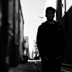 Young man standing against buildings in city