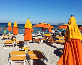 View of chairs on beach against clear blue sky