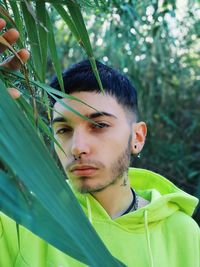 Close-up portrait of young man by plant