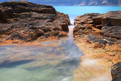 Panoramic shot of rocks in water against sky