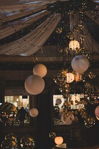 Illuminated lanterns hanging in building at night