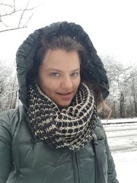 Close-up portrait of smiling young woman standing in winter